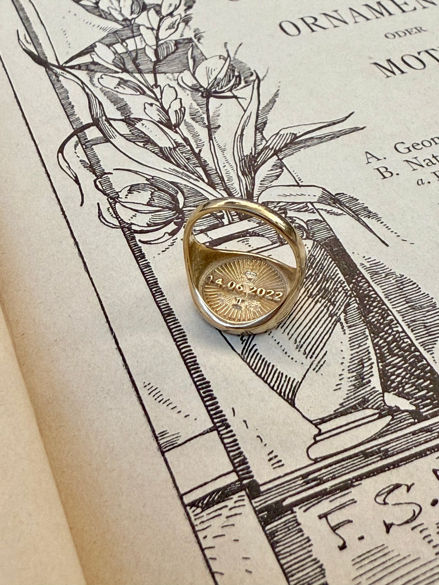 Sunburst signet ring gold 18k on antique book