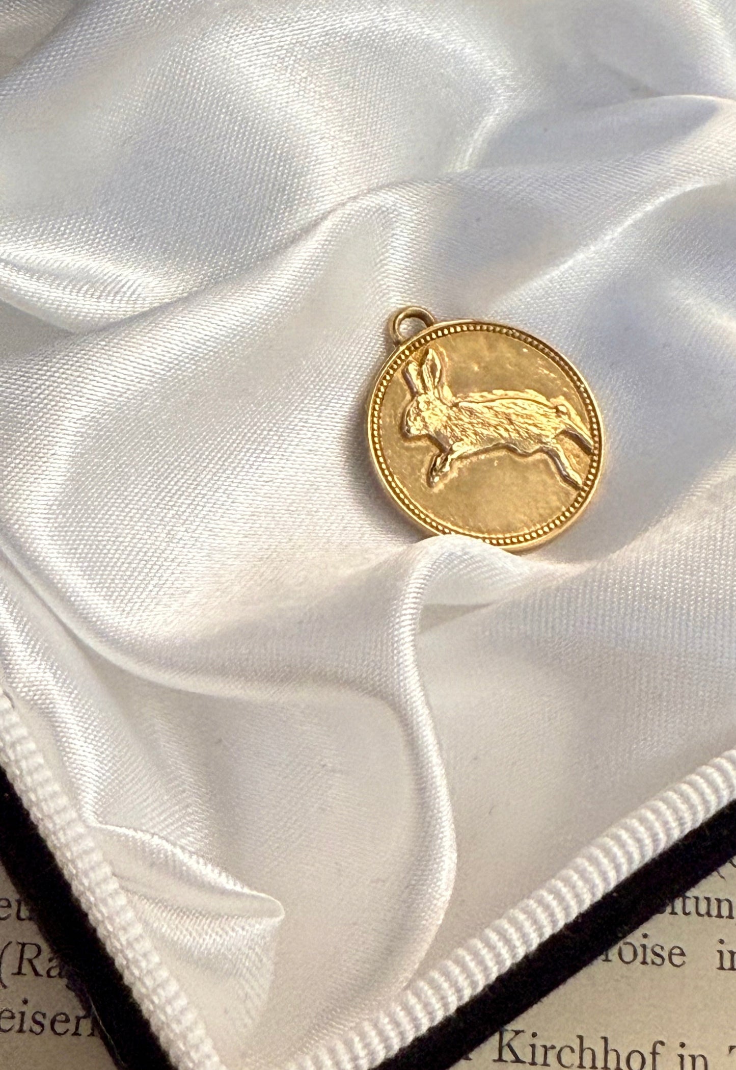 Hare medallion in solid gold 18k on white satin