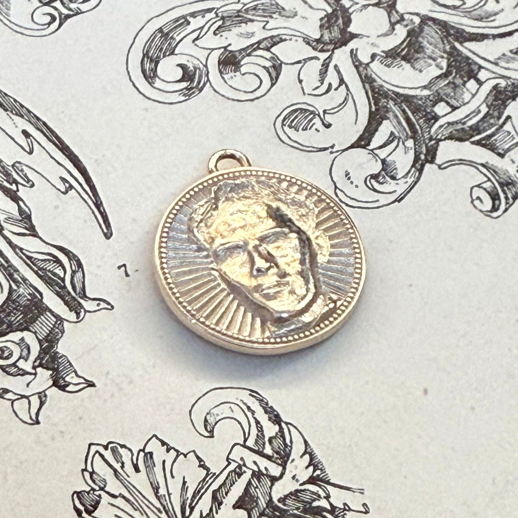 Personalized sunburst medallion in sterling silver on antique book